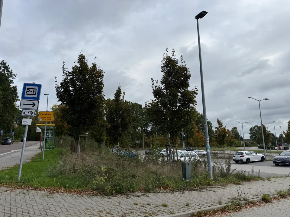 Park-and-Ride-Schild und Ortsschild Emmelndorf neben Bushaltestelle, Grünstreifen und Parkplatz mit abgestellten Autos