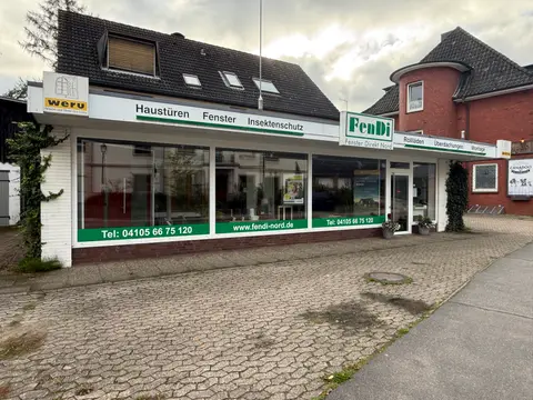 Ladenfront von FenDi Fenster Direkt Nord mit großen Schaufenstern, grünen Werbeschriftzügen und gepflastertem Vorplatz