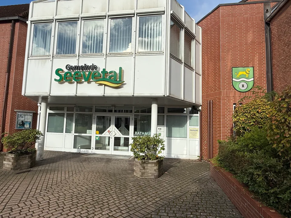 Eingang mit weißem Vorbau und Schriftzug Gemeinde Seevetal, daneben das Gemeindewappen an einer Klinkerwand